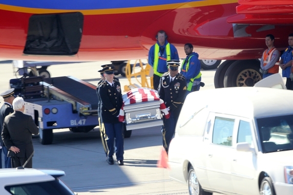 The remains of Las Vegan Sean Wayne Wells, 35, a sergeant first class assigned to the 2nd Battalion, 3rd Special Forces Group, are unloaded from a Southwest Airlines jet during a honorable transfe ...