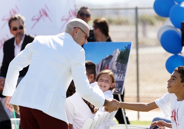 Rapper Pitbull shakes hands with a student at the start of a groundbreaking ceremony for Sports Leadership and Management (SLAM!) charter middle and high school Friday, Oct. 2, 2015, in Henderson. ...
