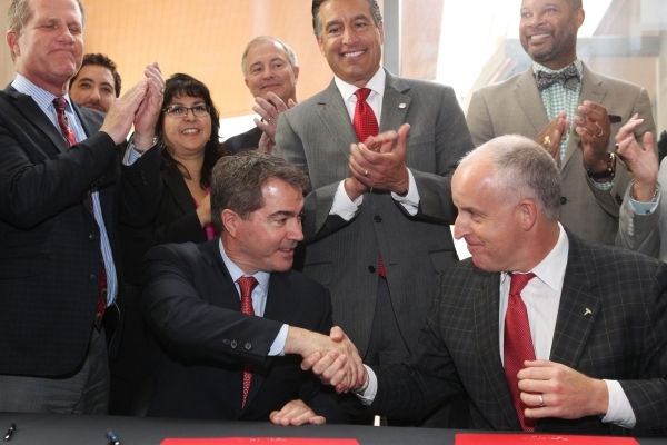 UNLV president Len Jessup, left, and Diarmuid O‘Connell, vice president at Tesla, shake hands after a ceremonial signing of a $1 million, 5-year-agreement between UNLV and Tesla to fund rese ...