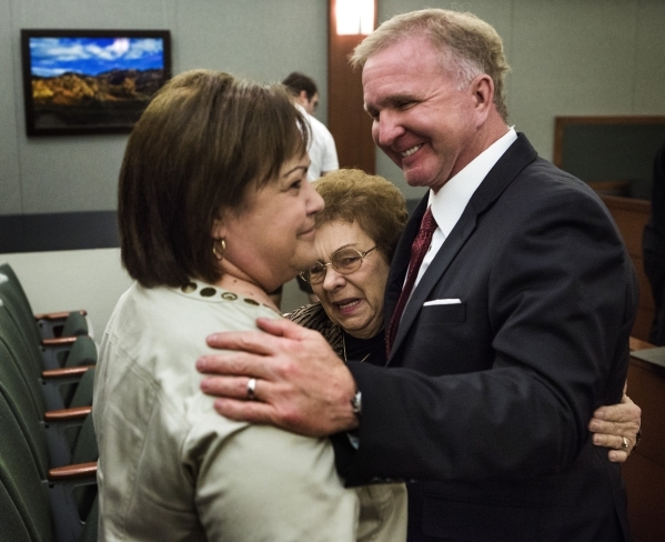 Attorney Robert Eglet, right, hugs Mary Iorio, center, the widow of Maurice Iorio, who died from bladder cancer complications in November 2013, and Pamela Kann, Maurice Iorio‘s sister, after ...