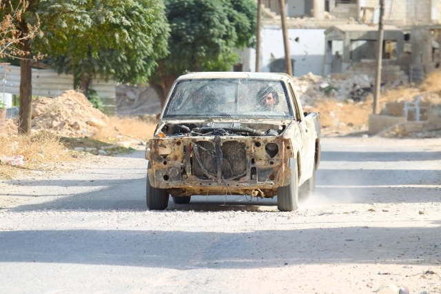 Rebel fighters drive a damaged vehicle in Latamneh city that was hit on Wednesday by Russian air strikes, in the northern countryside of Hama, Syria October 2, 2015. REUTERS/Ammar Abdullah