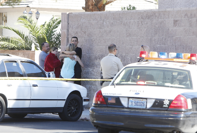 Evacuees watch as Las Vegas police are investigating a barricade situation where three people are dead after a shooting in a southeast valley neighborhood Friday, Oct. 2, 2015 in the 7200 block of ...