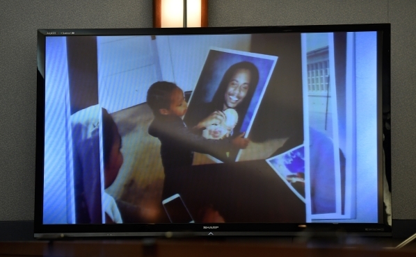 A video image is displayed of photograph of victim Kenny Cherry Jr. being held by one of his children during Ammar Harris‘s penalty hearing at the Regional Justice Center on Monday, Nov. 2,  ...
