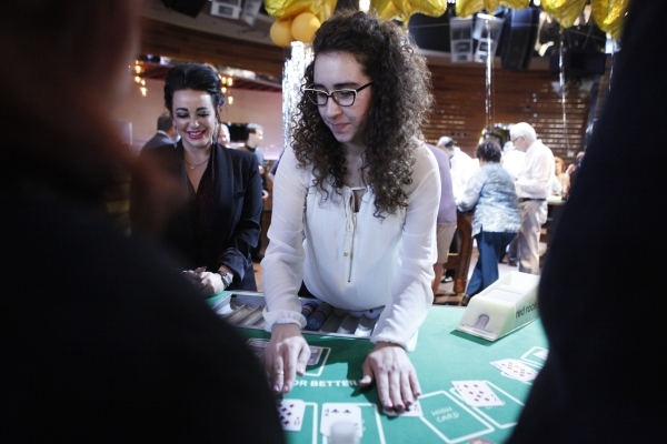 Heather Hagopian, right, deals a game of cards as Sarah Yoseloff, inventor of the game Casino Battle, looks over the game during an event at Red Rock casino-hotel where top Station Casinos players ...