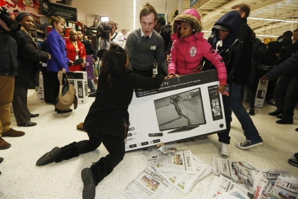 Shoppers wrestle over a television during a Black Friday sale last year in London. (Luke MacGregor/Reuters)