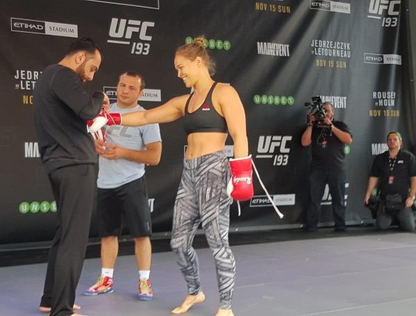 UFC women‘s bantamweight champion Ronda Rousey gets help with her gloves from coach Edmond Tarverdyan, left, Thursday at Federation Square in Melbourne, Australia, during open workouts for U ...