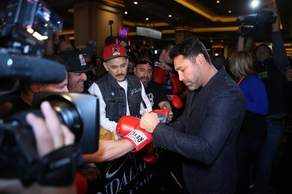 Boxing promoter and former professional boxing champion Oscar De La Hoya signs autographs during the grand arrivals event for Canelo Alvarez and Miguel Cotto at Mandalay Bay casino-hotel in Las Ve ...