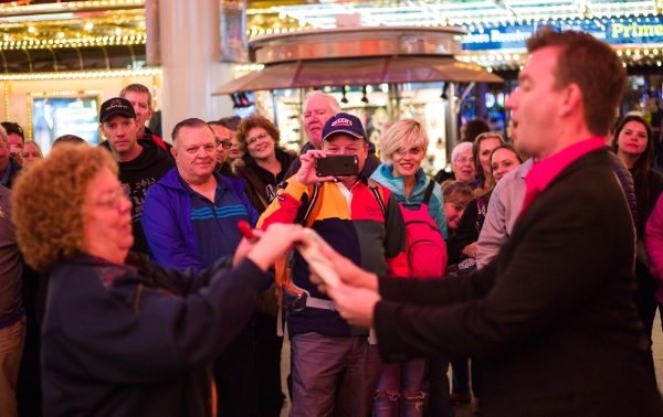 People watch magician Chris Randall perform on the Fremont Street Experience in downtown Las Vegas on Tuesday, Nov. 17, 2015. Tuesday was the first day of the city‘s new ordinance requiring  ...