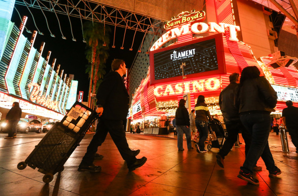 Magician Sean Scott, right, walks to a new location zone on the Fremont Street Experience in downtown Las Vegas on Tuesday, Nov. 17, 2015. Tuesday was the first day of the city‘s new ordinan ...