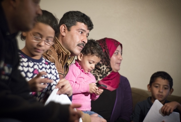 Syrian refugee family Khalid, father, center,  declined to give last name for security concerns, and is wife Safera, red scarf, with their children Adul Karim, 18, left, Retaj, 6, Zain Al Sham, 2, ...