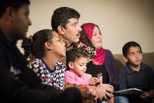 Syrian refugee family Khalid,  center,  declined to give last name for security concerns, and is wife Safera, red scarf, with their children Adul Karim, 18, left, Retaj, 6, Zain AlSham, 2, and  Al ...