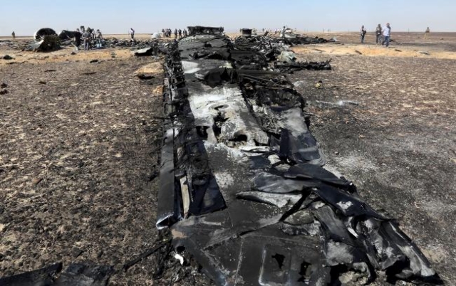 Military investigators from Egypt and Russia stand near the debris of a Russian airliner at the site of its crash at the Hassana area in Arish city, north Egypt, Nov. 1, 2015. (Mohamed Abd El Ghan ...