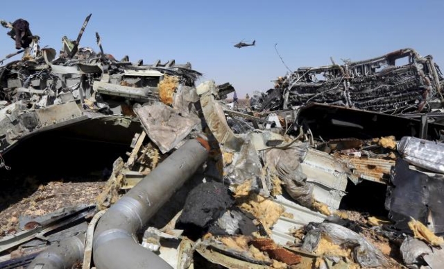 The remains of a Russian airliner are seen as an Egyptian military helicopter flies over the crash site in al-Hasanah area at El Arish city, north Egypt, Nov. 1, 2015. (Mohamed Abd El Ghany/Reuters)
