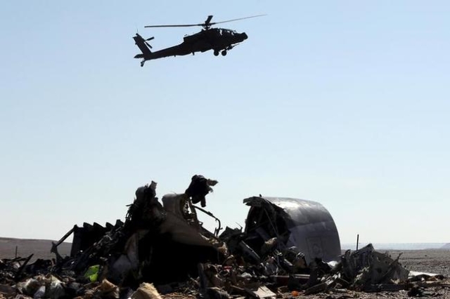 An Egyptian military helicopter flies over debris from a Russian airliner, which crashed at the Hassana area in Arish city, north Egypt, Nov. 1, 2015. (Mohamed Abd El Ghany)