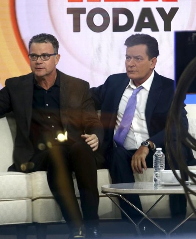 Actor Charlie Sheen, right, is seen through a window as he sits on the set of the NBC Today show prior to being interviewed by host Matt Lauer, Nov. 17, 2015. (Reuters/Mike Segar)