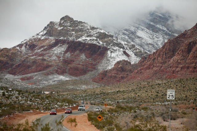 Cars travel along Calico Basin Road and snowfall can be seen at Red Rock Canyon National Conservation Area Monday, Feb. 23, 2015, in Las Vegas. (Ronda Churchill/Las Vegas Review-Journal)