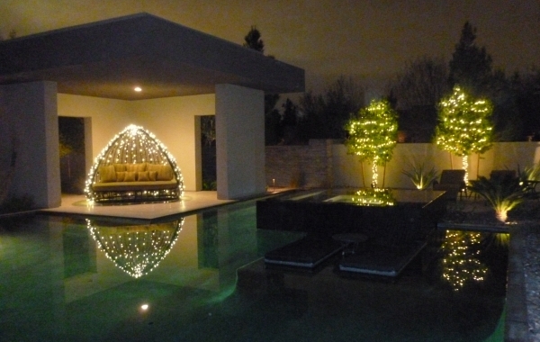 The pool area is a perfect place to string lights, which reflect off the water.  COURTESY COURTNEY LIGHTS