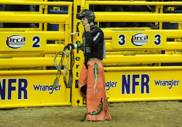 Bull rider Sage Kimzey from Strong City, Okla., reacts after being bucked from his bull during the first go-round of the 2015 Wrangler National Finals Rodeo at the Thomas & Mack Center in Las  ...