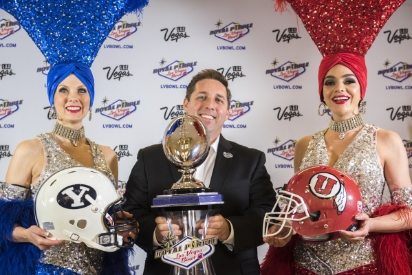 Las Vegas Bowl Executive Director John Saccenti, center, poses with showgirls Jennifer Autry, left, and Porsha Revesz at a press conference in Las Vegas on Sunday, Dec. 6, 2015. BYU will take on   ...