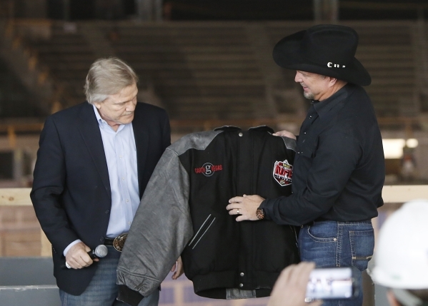 Artist Garth Brooks, right, receives the official Wrangler "Garth Vegas" jacket from Pat Christenson, president of Las Vegas Events, at the new Las Vegas MGM-AEG Arena during a press con ...
