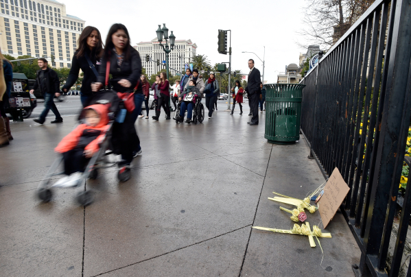 People walk past a memorial on the Strip between the Paris Las Vegas and Planet Hollywood hotels Monday, Dec. 21, 2015. One person died and 35 were injured when a car driven by Lakeisha N. Hollowa ...