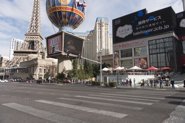 People walk on the sidewalk in front of Paris Las Vegas and Planet Hollywood Resort & Casino in Las Vegas on Monday, Dec. 21, 2015. Jason Ogulnik/Las Vegas Review-Journal.