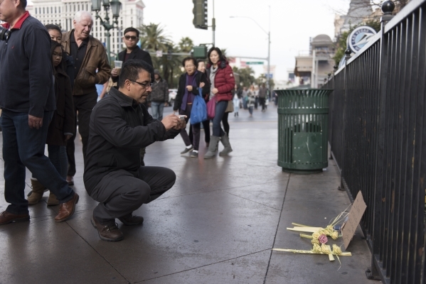 Raul Dorantes takes a photo of the memorial dedicated to the victims of the car crash that took place Sunday night outside of Planet Hollywood Resort & Casino and Paris Las Vegas in Las Vegas  ...