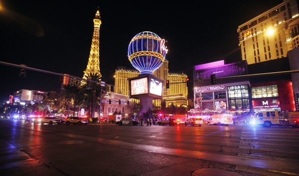 Police investigate the scene on the Las Vegas Strip outside Paris Las Vegas on Sunday, Dec. 20, 2015, after a car plowed into pedestrians on the sidewalk, killing one person and injuring 37 people ...