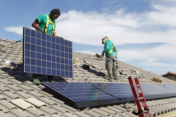 Solar City installation crew leader Greg Kates, left, and Guillermo Aviles install solar panels on a North Las Vegas home Thursday, Oct. 30, 2014. (Sam Morris/Las Vegas Review-Journal)
