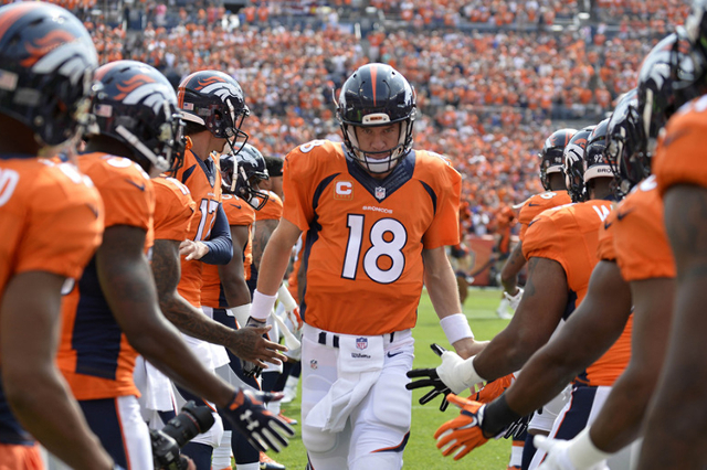 Sep 13, 2015; Denver, CO, USA; Denver Broncos quarterback Peyton Manning (18) high fives teammates prior to their game against the Baltimore Ravens at Sports Authority Field at Mile High. (Ron Che ...