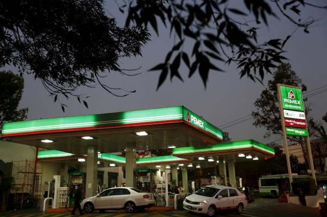 Vehicles are seen beside fuel pumps at a Pemex gas station in Mexico City, in this January 13, 2015 file photo. Up to $2 trillion in petroleum and coal projects will not be needed if the world tak ...