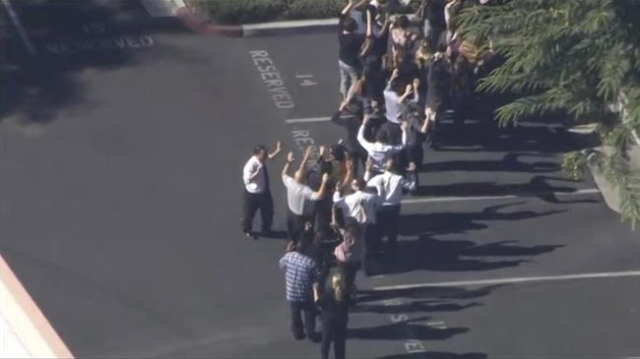 A still image from a video footage courtesy of Nbcla.com shows people lining up as first responders respond to shooting at the California Department of Developmental Services Inland Regional Cente ...