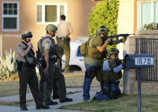Police officers conduct a manhunt after a mass shooting in San Bernardino, December 2, 2015. REUTERS/Mike Blake