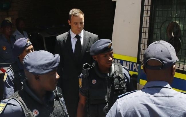 South African Olympic and Paralympic sprinter Oscar Pistorius (C ) is escorted to a police van after his sentencing at the North Gauteng High Court in Pretoria in this October 21, 2014 file photo. ...