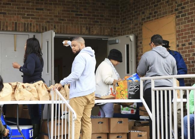 Members of the Hopewell Baptist church give out food after a tornado caused damage in a neighborhood in Birmingham, Alabama, December 26, 2015.  REUTERS/Marvin Gentry