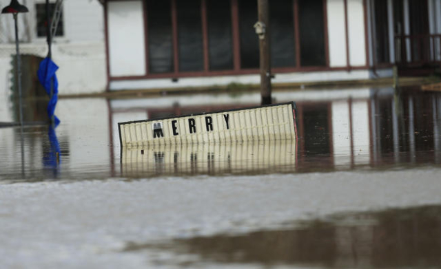 A sign sits underwater located in the downtown area of Elba, Alabama, December 26, 2015.  REUTERS/Marvin Gentry
