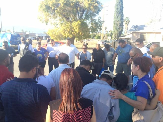 A prayer circle forms at The Rock Church in San Bernardino after a shooting at the Inland Regional Center.