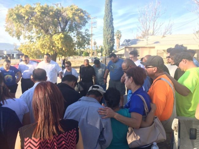 A prayer circle forms at The Rock Church in San Bernardino after a shooting at the Inland Regional Center. (CNN)