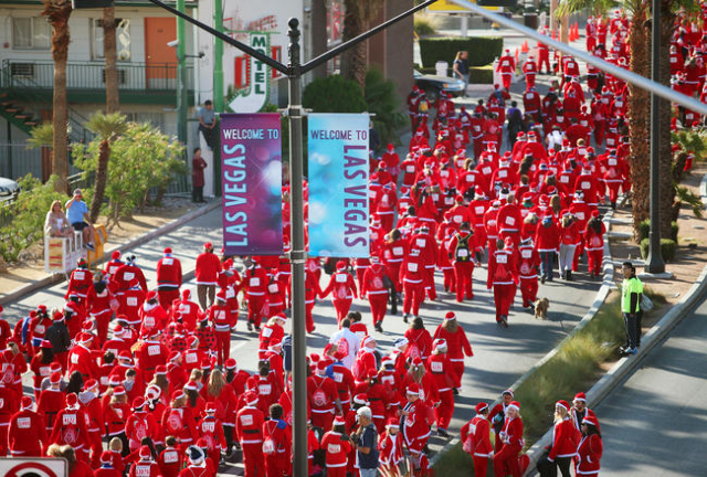 Participants dressed in Santa suits make their way south on Las Vegas Boulevard during the 10th annual Las Vegas Great Santa Run Saturday, Dec. 6, 2014, in Las Vegas. (Ronda Churchill/Las Vegas R ...