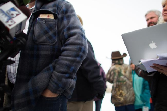 Ammon Bundy, with a copy of the U.S. constitution in his pocket, speaks with reporters at a news conference by the entrance of Malheur National Wildlife Refuge near Burns, Ore. on Monday, Jan. 4, ...