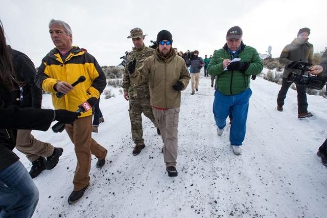 Anti-government protestor Jon Ritzheimer, center, walks from the entrance of Malheur National Wildlife Refuge headquarters, which the group is occupying, near Burns, Ore. on Monday, Jan. 4, 2016. ...