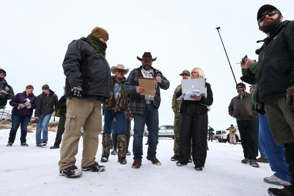 Ammon Bundy, center, prepares to speak with reporters at a news conference by the entrance of Malheur National Wildlife Refuge near Burns, Ore., on Monday, Jan. 4, 2016. Bundy, who is the son of N ...