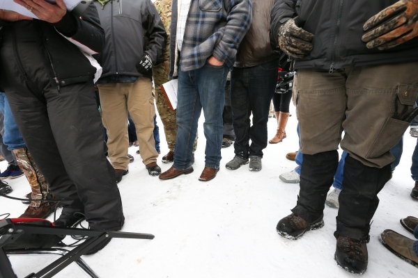 Ammon Bundy, center, stands as Shawna Cox, far left, gives a statement to reporters at a news conference by the entrance of Malheur National Wildlife Refuge near Burns, Ore., on Monday, Jan. 4, 20 ...