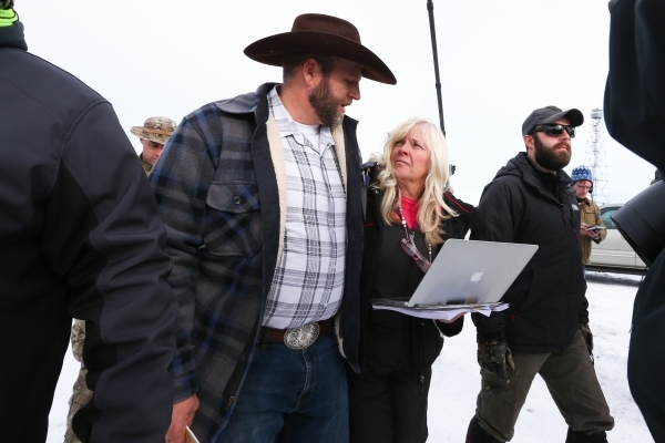 Ammon Bundy, with Shawna Cox, of Utah, arrives to speak with reporters at a news conference by the entrance of Malheur National Wildlife Refuge near Burns, Ore., on Monday, Jan. 4, 2016. Bundy, th ...