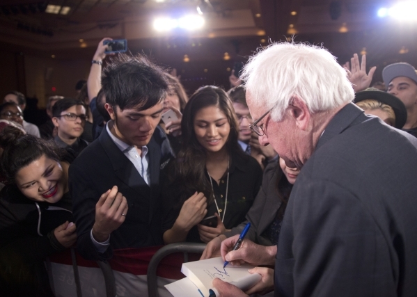 Democratic presidential candidate Sen. Bernie Sanders, I-Vt., signs a copy of his book during the "Future to Believe In" rally supporting Sanders inside the Tropicana hotel-casino in Las ...