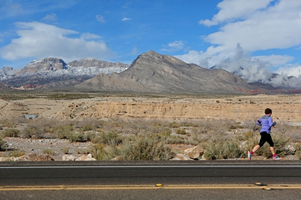 A jogger runs east on state Route 159 near a cloudy and snow-topped Red Rock Canyon National Conservation Area Wednesday, Jan. 6, 2016, near Las Vegas. Ronda Churchill/Las Vegas Review-Journal