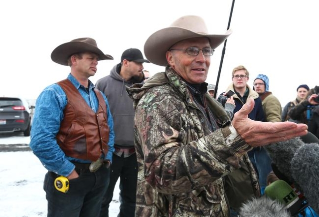 Arizona rancher and anti-government protester LaVoy Finicum, right, talks with reporters as Ryan Bundy, left, looks on, by the entrance of the Malheur National Wildlife Refuge headquarters, which  ...