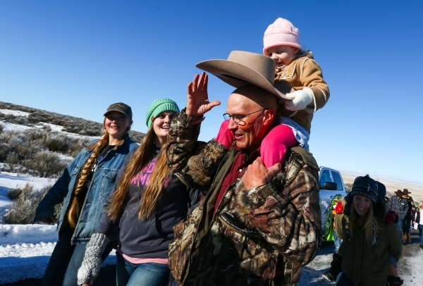 Arizona rancher and anti-government protester LaVoy Finicum, with his granddaughter Payton Beck, 3, walks towards the entrance of the Malheur National Wildlife Refuge headquarters, which the group ...