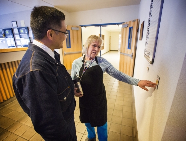 Employee Cheryl Smith explains to Michael Kobori, VP of sustainability for  Levi Strauss & Company, at light switch plate she created at the Levi Strauss & Company‘s Sky Harbor Distr ...