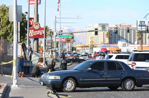 Las Vegas police and a coroner inspect the sidewalk in front of the bus stop that was hit by a bus in a fatal accident on West Tropicana Avenue near Dean Martin Drive in Las Vegas on Saturday, Jan ...